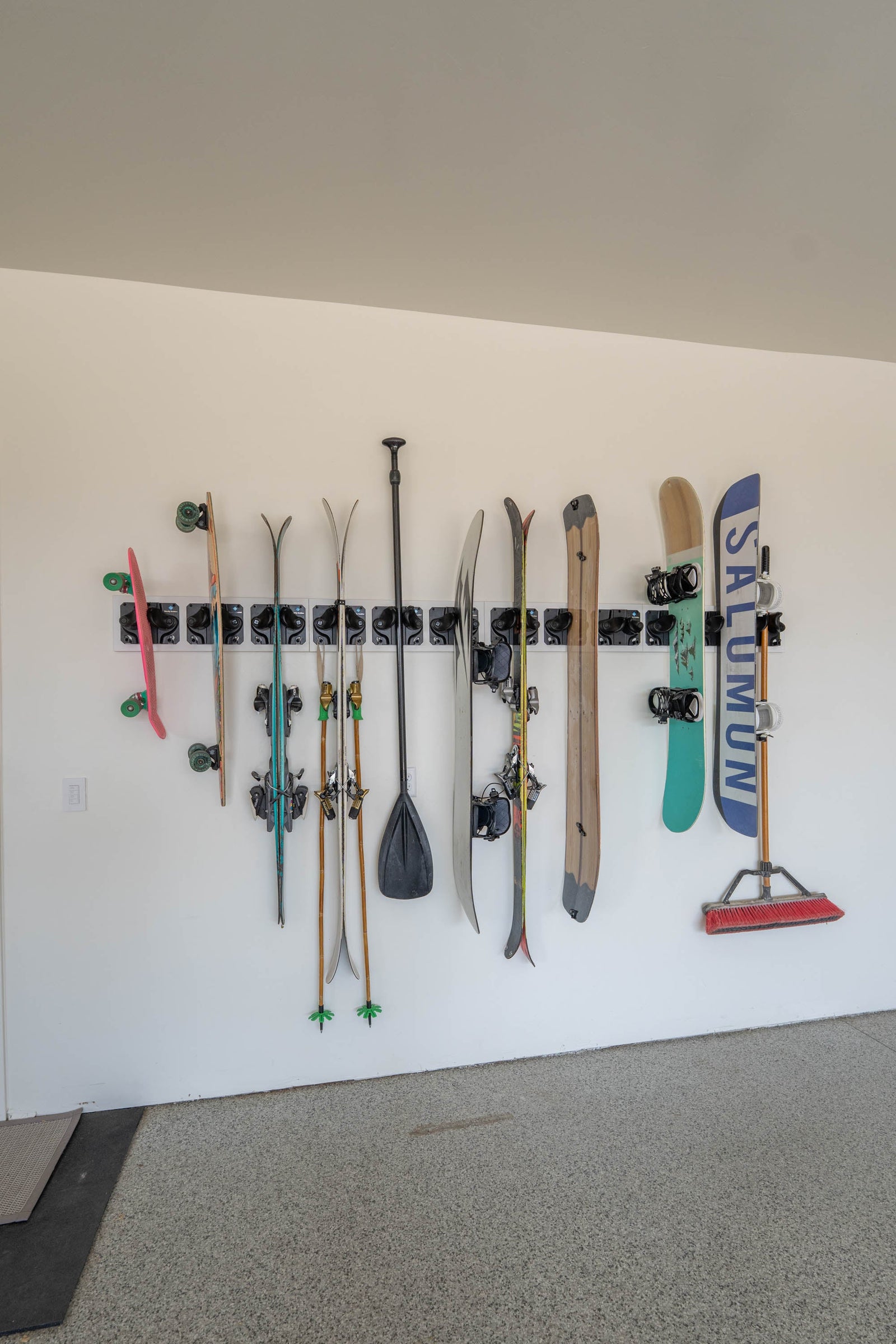 Gravity Grabber storing skis vertically without pinching tips in a clean garage setup